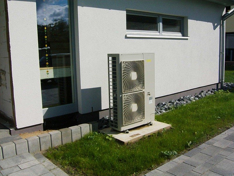 Außeneinheit der Wärmepumpe steht aufgesockelt vor dem Haus Foto: Rotex