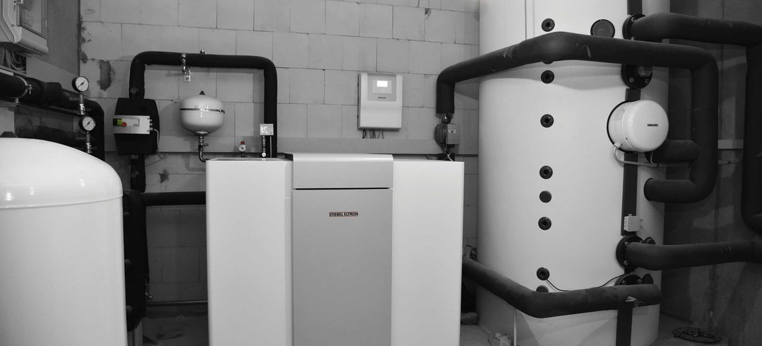 Die Wärmepumpe WPF 27 gewinnt Umweltenergie aus dem Grundwasser. Im Hintergrund der Wärmepumpenmanager WPM System sowie rechts der 1.500-Liter-Pufferspeicher. (Foto: Stiebel Eltron)