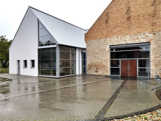 Das moderne Dorfgemeinschaftshaus in Hillesheim deckt seinen Restwärmebedarf über eine Geothermie-Wärmepumpe, die mit PV-Strom versorgt wird. (Foto: waermepumpe-regional.de)